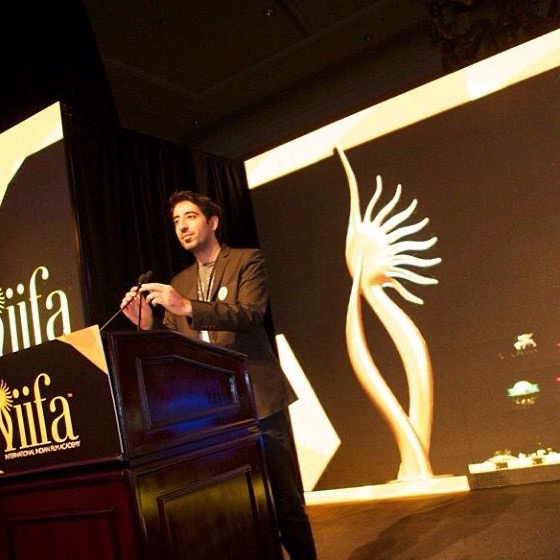 Kaiser Khan speaking on stage at IIFA
